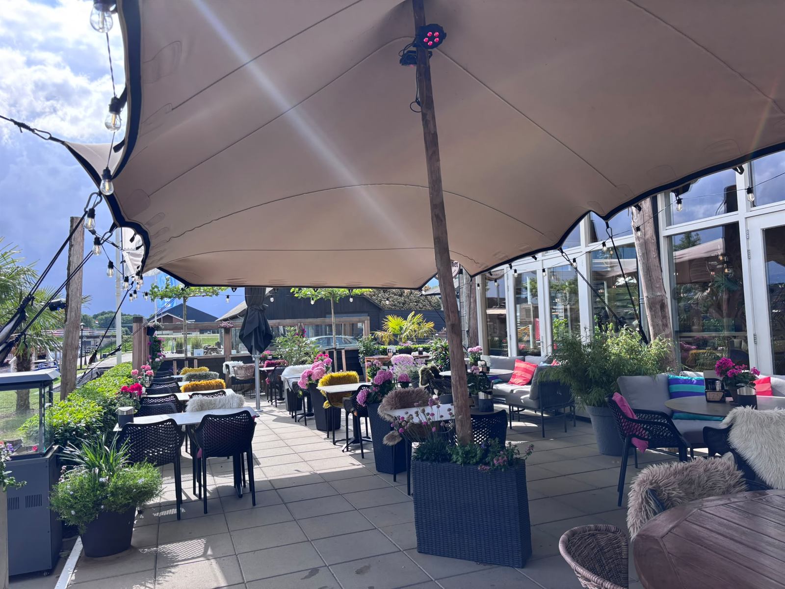 Loungehoek op het terras met banken, kussens en flessen
